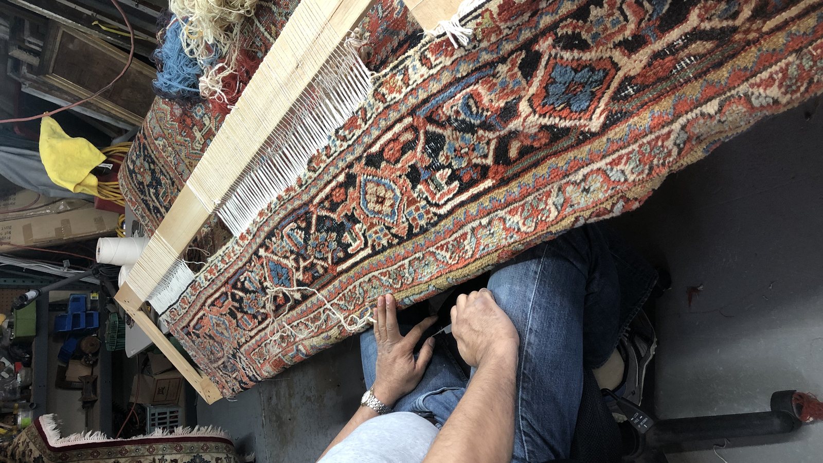 Matched wool being knotted back into an oriental rug at the repair bench